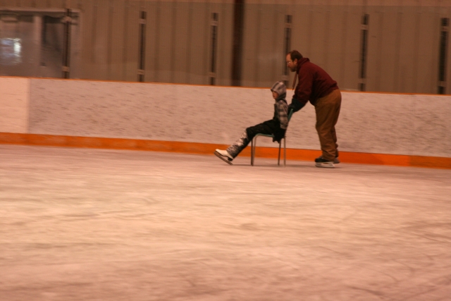 Jonathan enjoying a ride from Dad on the ice rink